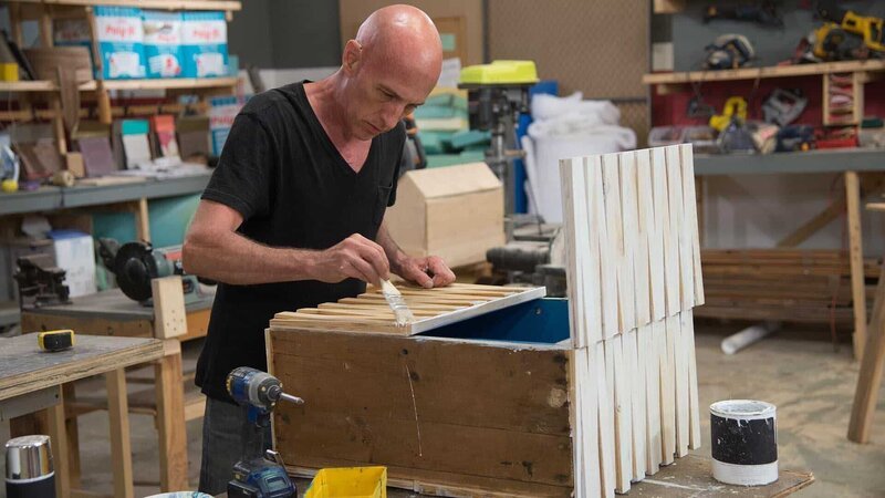 In the workshop contestant Robert applies white paint to the front of his unhinged project. As seen on HGTV’s Flea Market Flip – Bild: 2017, Scripps Networks, LLC. All Rights Reserved.