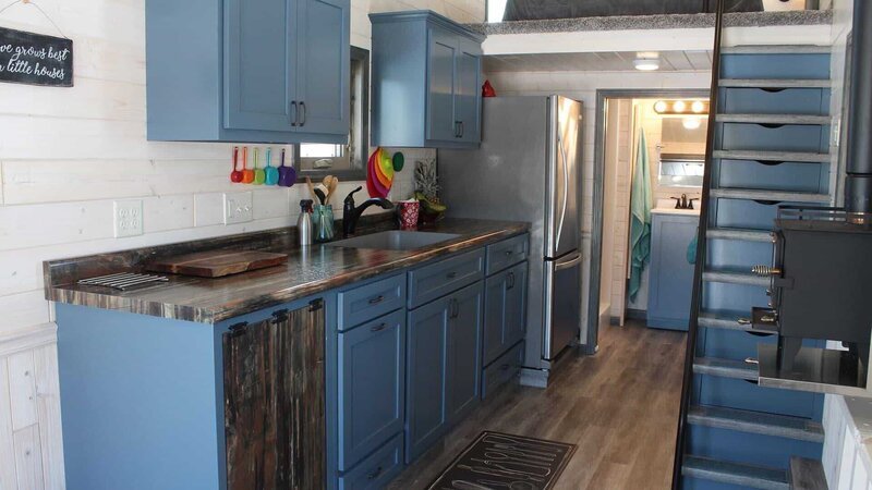 The blue kitchen cabinets bring in a good pop of color to the white washed interior, for Steve and Holly Schuett’s tiny house build, in Gleason, Wisconsin, as seen on Tiny House, Big Living. – Bild: 2018, Scripps Networks, LLC. All Rights Reserved.