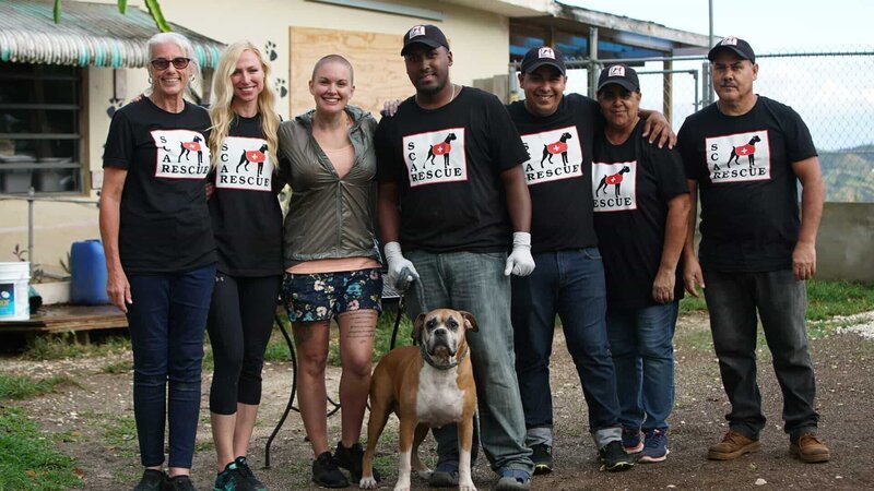 Bonnie, Tara, and Amanda pose for a picture with the volunteers who work at Second Chance Animal Rescue. – Bild: Discovery Community