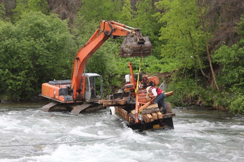 Ein Bagger verhindert, dass der Lkw in den Sustina River kippt, während Marty Raney sich festhält. – Bild: Scott Sandman /​ Discovery Communications, LLC