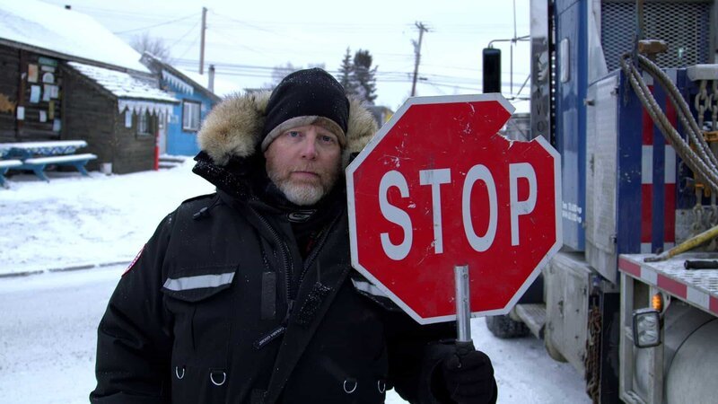 Male holds a stop sign and looks into the camera. – Bild: Discovery Communications, Inc.