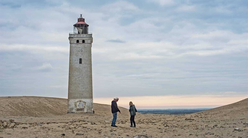 Die Urlaubschecker Ingrid und Matthias vor dem Leuchtturm Rubjerg Knude Fyr in Nordjütland. – Bild: ZDF und NDR/​Linus Koch.