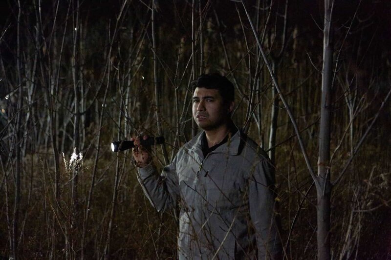 Jason Amos durchsucht den Wald mit einer Taschenlampe. – Bild: RTL /​ © Saloon Media