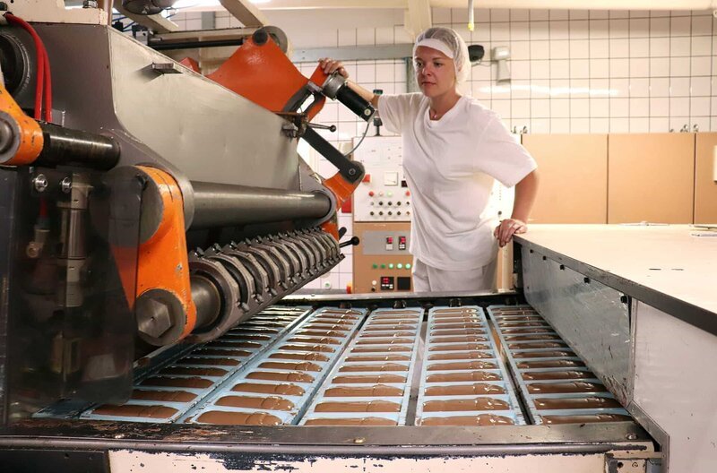 Mitarbeiterin Nadine Schuster an der Gießanlage für Schokoladentafeln – Bild: ZDF und MDR/​Rolf Sakulowski.