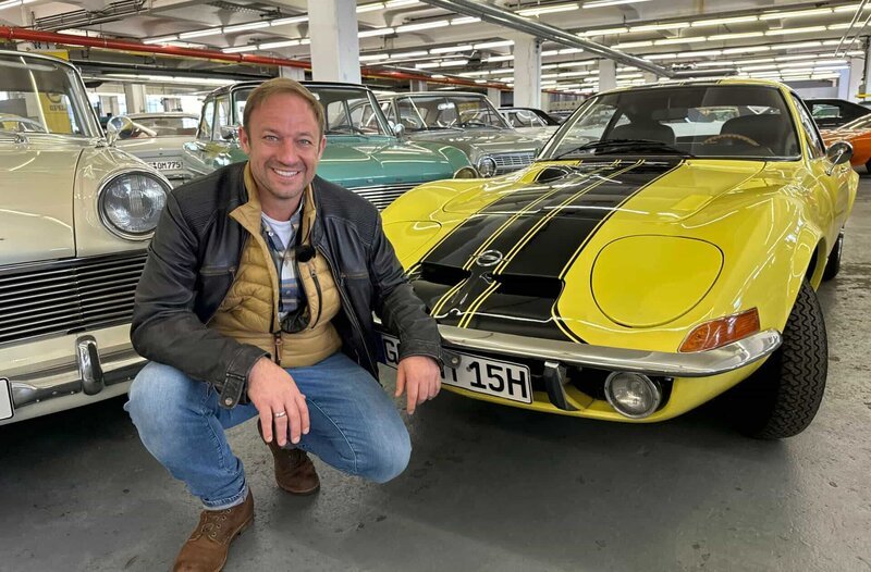 Tobias Kämmerer neben einem echten Klassiker aus Rüsselsheim, einem Opel GT. – Bild: HR/​Lukas Lowack
