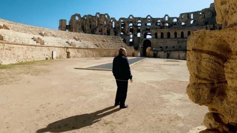Der Archäologe Nejib ben Lazreg untersucht das Kolosseum von El Jem in Tunesien. – Bild: Remote shooting team/​ Windfall F /​ Photobank /​ 37738_507_024 /​ Windfall Films Ltd.