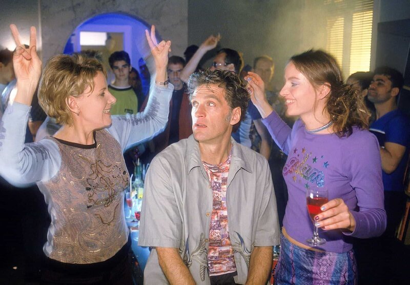 Nikola (Mariele Millowitsch, l.) und Schmidt (Walter Sittler) versuchen auf der Rave-Party einander an Dynamik zu überbieten. Christine (Karo Guthke) beobachtet das Tanzduell amüsiert … – Bild: RTLplus