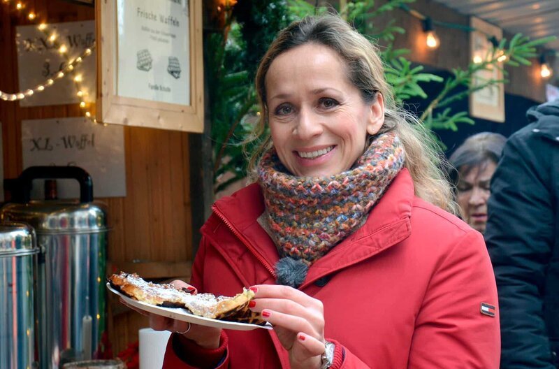 Moderatorin Tamina Kallert beim Waffelessen auf dem Weihnachtsmarkt im Wildwald Arnsberg-Vosswinkel. – Bild: WDR/​Jutta Brinkmann