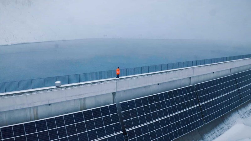 NZZ Format Die grosse Stromlücke – Was passieren muss, damit die Schweiz im Winter genügend Strom hat Staumauer mit Photovoltaikanlage – Bild: SRF/​NZZ Format