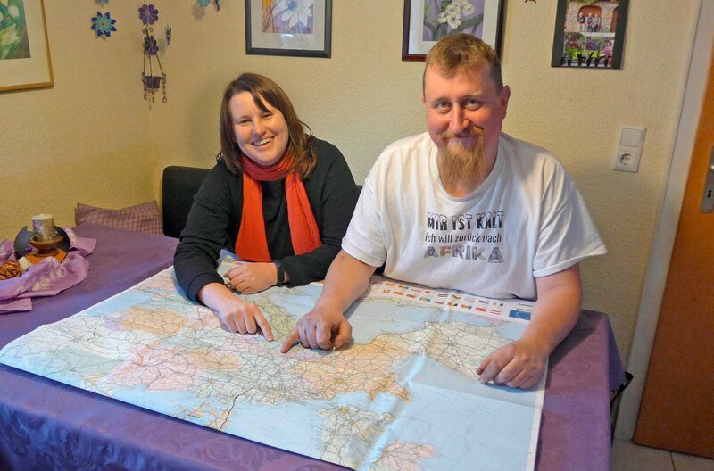 Verena und Patrick Fuchs zeigen im Haus der Großeltern in Leutkirch auf der Karte ihre geplante Reiseroute. – Bild: phoenix/​SWR