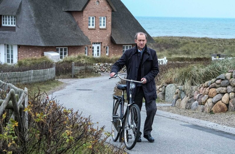 Im Bild: Zum einen hat Carl Sievers (Peter Heinrich Brix) hat eine geheimnisvolle Verabredung und warum zum anderen nimmt er lieber das Fahrrad als das Auto? Hat das eine etwas mit dem anderen zu tun? – Bild: Marion von der Mehden /​ ORF /​ ZDF