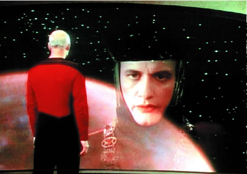 Q (John DeLancie, r.), der über unbegrenzte übersinnliche Kräfte verfügt, erscheint auf dem Bildschirm der Enterprise und warnt Captain Picard (Patrick Stewart, l.). – Bild: SYFY