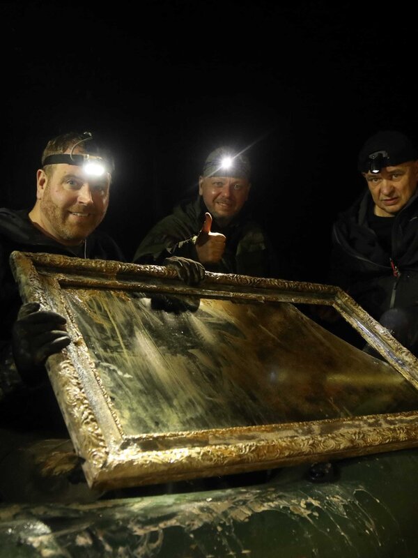 L-R: Josh Gates und die Ermittler Pawel Piatkiewicz und Robert Kubiszekski entdecken in dem Nazitunnel einen verfallenen Bilderrahmen aus Holz und Glas. – Bild: Adam Kostylo /​ Ping Pong Productions /​ Photobank /​ 37781_ep711_006 /​ Discovery Communications, LLC