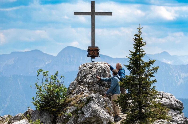 Geschafft! Hubert (Christian Tramitz, l.) und Girwidz (Michaal Brandner, r.) haben das Gipfelkreuz erreicht. Das Gipfelbuch ist in greifbarer Nähe – zumindest Girwidz freut sich. – Bild: ARD/​Thomas Neumeier