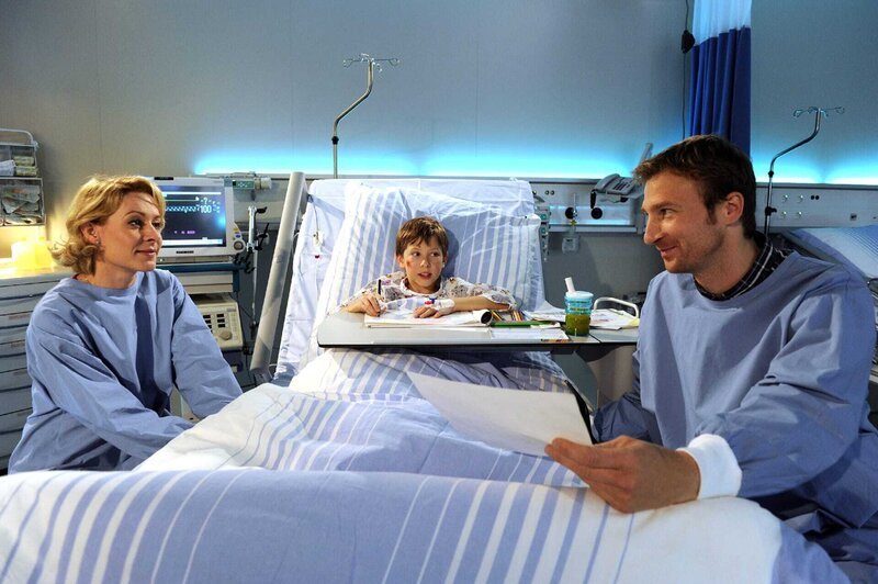 Hans Gruber (Heiko Ruprecht, r.) besucht Jonas (Fabian Elias Huber, m.) im Krankenhaus. Auch Susanne (Natalie O’Hara, l.) sitzt am Bett ihres Sohnes. – Bild: ORF/​ZDF/​Thomas R. Schumann