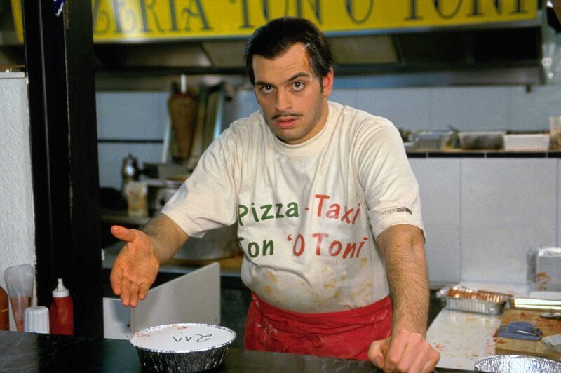 Der italienische Pizzabäcker Carlos (Kaya Yanar) präsentiert Ton 'O Tonis Lasagne-Spezialität Nr.211. – Bild: SAT.1 /​ Guido Engels Eigenproduktionsbild frei