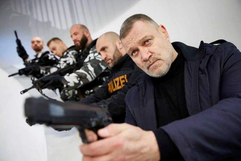 Der Drahtzieher Roman Krivosia (Robert Jarczyk, r.) versucht mit seinen Männern unbemerkt das Bürogebäude zu verlassen … – Bild: RTL /​ Guido Engels