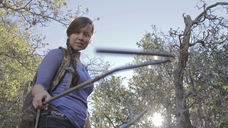 Hannah Lockhart holding a snake hook while searching. – Bild: Discovery Communications