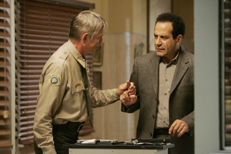 Monk (Tony Shalhoub) wird des Mordes verdächtigt und von Sheriff Rollings (Scott Glenn, li.) festgenommen. – Bild: RTLplus /​ Universal