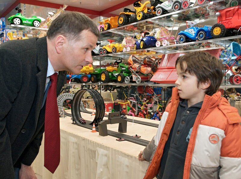 Roland Heilmann (Thomas Rühmann, links) ist mit seinem Enkel Jonas (Anthony Petrifke) im Spielzeugladen und hat alle Hände voll zu tun, ihm eine teure Autorennbahn auszureden. – Bild: MDR/​Krajewsky