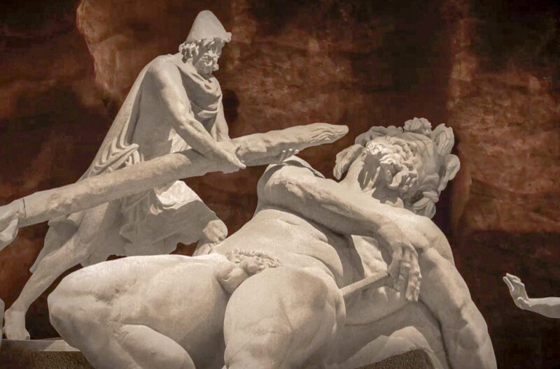 Um sich aus den Fängen des Zyklopen zu befreien, ergreifen Odysseus und seine Männer einen gespitzten Pfahl und rammen ihn mit vereinten Kräften in das Auge des Ungeheuers. – Bild: Rosebud Productions /​ © Rosebud Productions