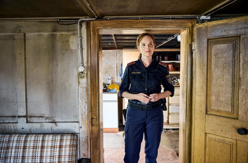 Dorfpolizistin Sophie Landner (Julia Koch) im Haus der Güggalar – Bild: ORF/​Manuel Riesterer /​ Dorfpolizistin Sophie Landner (Julia Koch) im Haus der Güggalar