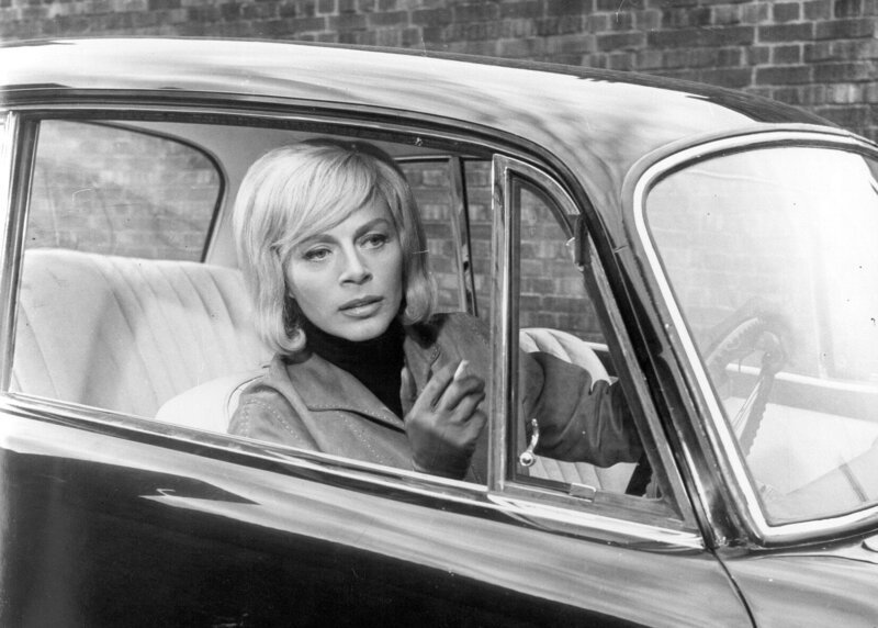Dinah (Margot Trooger) gehört einer Gangsterbande an. Ihre Aufgabe ist es, den Fluchtwagen zu fahren … – Bild: RTL /​ © 1964 Tobis Film
