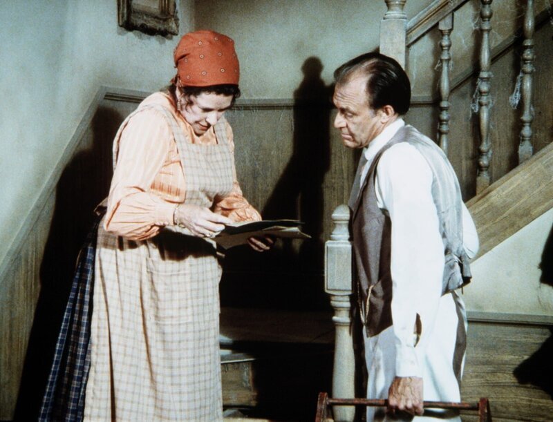 Harriet Oleson (Katherine MacGregor, l.) zeigt ihrem Mann Nels (Richard Bull, r.) alte Papiere, die sie unter einer Treppenstufe gefunden hat. – Bild: Worldvision Lizenzbild frei