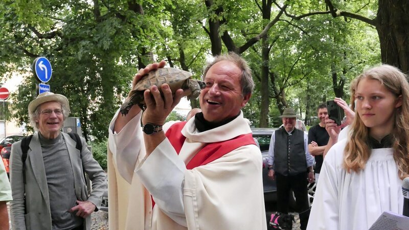 Pfarrer Schießler ist bekannt für seine ungewöhnlichen Aktionen in der Pfarrei, wie die Viecherlmesse im Juli, bei der er Haustiere segnet. – Bild: BR/​Daniela Agostini/​Daniela Agostini