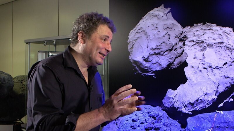 Christian Krause vom Kontrollzentrum der Mascot-Mission vor dem Bild eines Asteroiden, auf dem der Vorgänger-Lander Philae landete. – Bild: BR/​Maximilian Schecker /​ Maximilian Schecker
