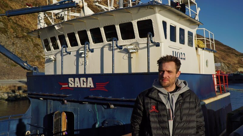 Captain Jake Anderson stands in front of his boat, the Saga, at dock. – Bild: Discovery Communications