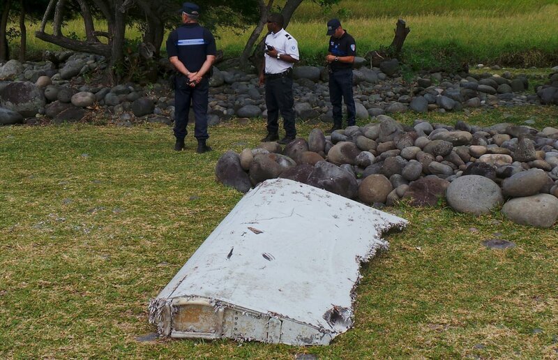 French gendarmes and police stand near a large piece of plane debris which was found on the beach in Saint-Andre, on the French Indian Ocean island of La Reunion, July 29, 2015. France’s BEA air crash investigation agency said it was examining the debris, in coordination with Malaysian and Australian authorities, to determine whether it came from Malaysia Airlines Flight MH370, which vanished last year in one of the biggest mysteries in aviation history. Picture taken July 29, 2015. REUTERS/​Zinfos974/​Prisca Bigot – Bild: STRINGER/​FRANCE /​ Reuters /​ X01282 /​ Public Domain; Journal Del’Ile de la Reunion