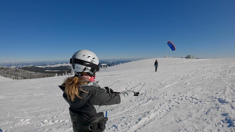 Laura will Snowkiten lernen. Dafür muss sie erst einmal lernen und üben, wie man einen Kite fliegen lässt und lenken kann. Das ist nämlich eine Herausforderung für sich. – Bild: ZDF/​Sandra Palm