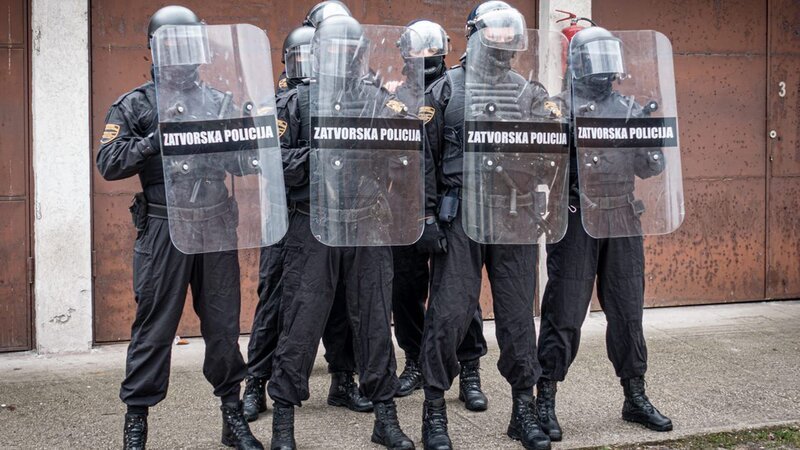 Das Training der Wärter findet gezielt abseits der Gefängnismauer statt um ihre Einsatz-Strategie geheim zu halten. Ein Teil der Spezialeinheit der Gefängnis-Polizei ist immer in Bereitschaft, falls es zu Ausschreitungen oder Schlägereien kommt. Zu ihren Waffen zählen Schutzschild, Handschellen und ein Schlagstock. – Bild: WELT