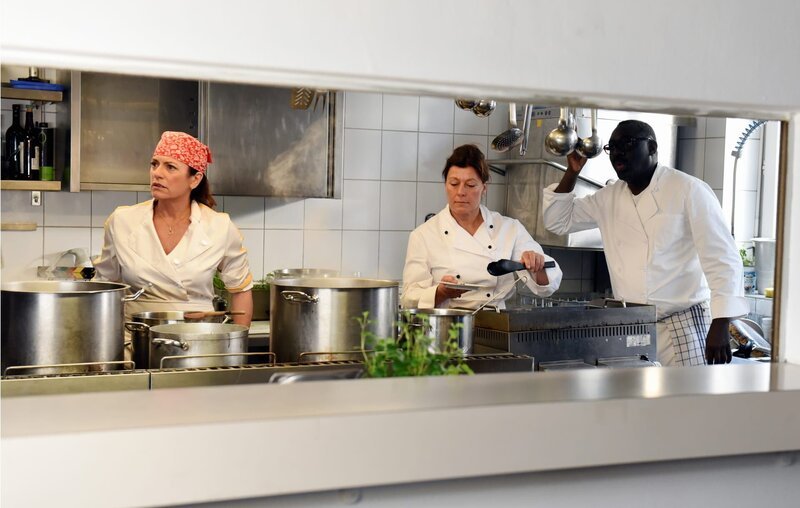 Die Küchencrew im Einsatz. Von links: Toni (Christine Neubauer), Hannah (Barbara Langwallner) und Pharao (Isaak Cissé). – Bild: BR/​Günther Reisp