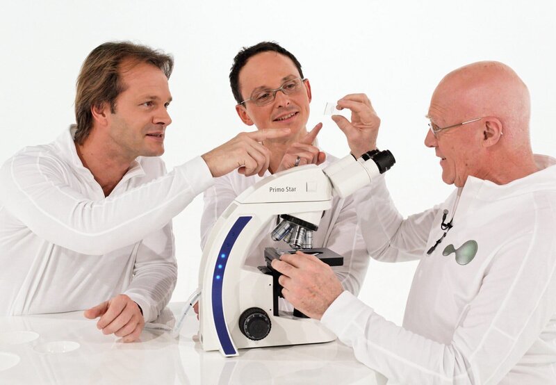 Aart Gisolf (rechts) erklärt seinen Studiokollegen Oliver Sandrock (links) und Axel Wagner (Mitte), den Aufbau einer Zelle. – Bild: SWR/​Peter A. Schmidt