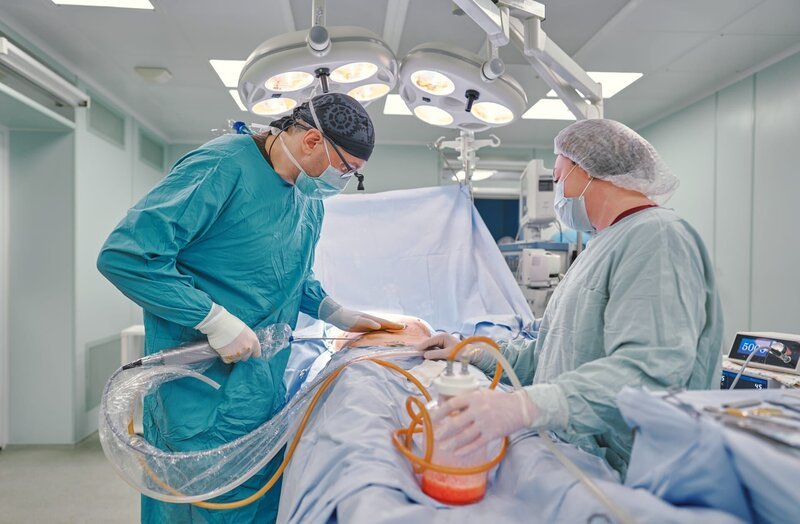 surgeon during liposuction in the operating room – Bild: Shutterstock /​ Shutterstock /​ Copyright (c) 2021 Aleksandr Lupin/​Shutterstock. No use without permission.