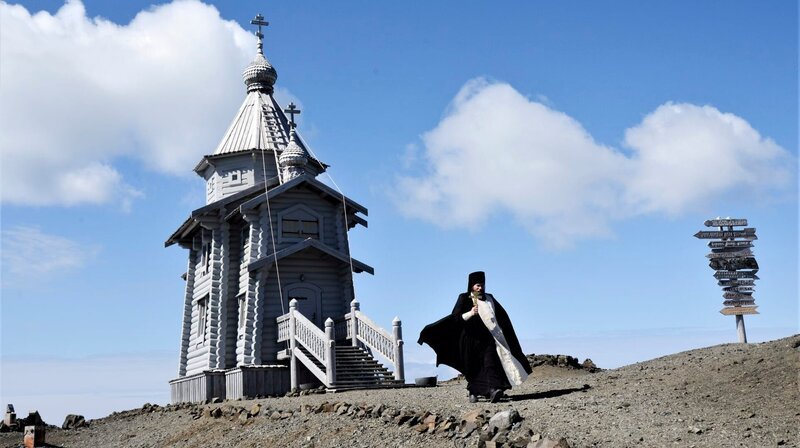 Sogar eine russisch-orthodoxe Kapelle gibt es in der Antarktis. Pope Palladiy bei der Wasserweihe. Er ist für russischen Forscher hier, kümmert sich aber auch um die Bewohner von acht weiteren Stationen aus aller Welt. – Bild: rbb/​NDR/​Vision Airways/​Joanna Michna