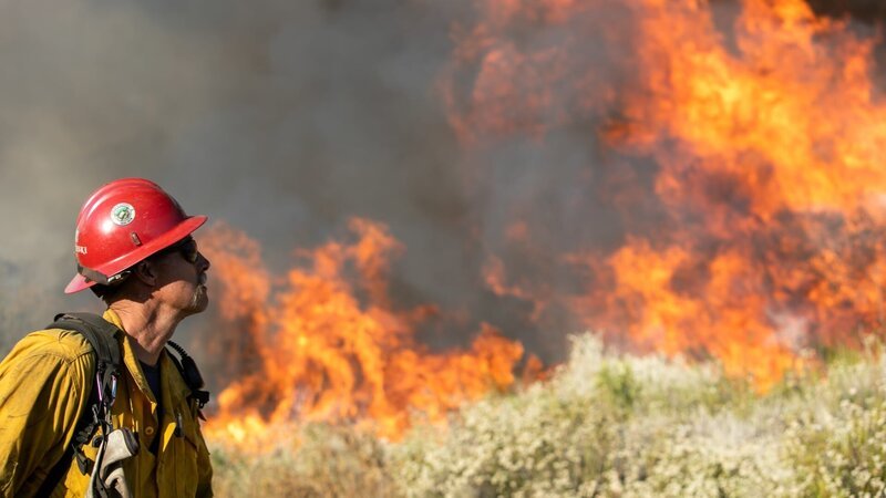 Ein Feuerwehrmann bereitet sich auf den Einsatz beim Apple Fire in den San Bernardino Mountains vor. – Bild: Discovery Communications, LLC