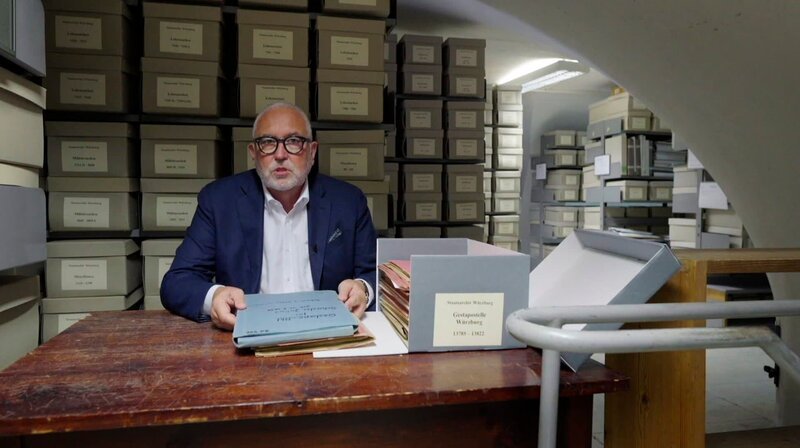 Andreas Bönte mit Akten der Geheimen Staatspolizei Würzburg im Magazin des Staatsarchivs Würzburg. – Bild: BR/Tino Müller Andreas Bönte mit Akten der Geheimen Staatspolizei Würzburg im Magazin des Staatsarchivs Würzburg. – Bild: BR/Tino Müller