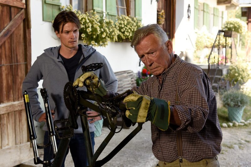 Nach Charlys (Julian Waldner, l.) Fahrradpanne kümmert sich Franz (Heinz Marecek, r.) fachmännisch um die Reparatur. – Bild: ZDF und Barbara Bauriedl.