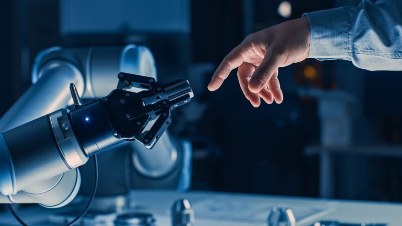 Futuristic Robot Arm Touches Human Hand – Bild: Shutterstock /​ Shutterstock /​ Copyright (c) 2019 Gorodenkoff/​Shutterstock. No use without permission.