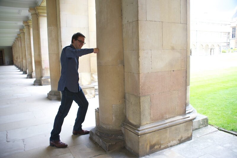 David Tong, theoretischer Physiker an der University of Cambridge, zeigt, dass die Säule, gegen die er schlägt, echt ist. – Bild: ZDF und Discovery Communications