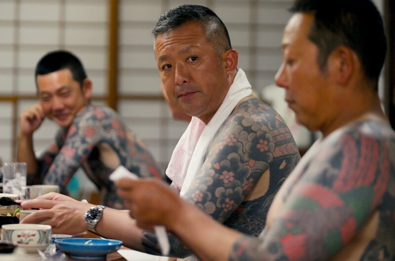 Taisuke Miyamoto (Mi.) trägt eine Tätowierung, die noch traditionell nur mit roter und schwarzer Farbe gestochen wurde. – Bild: ZDF /​ © Jiro Akiba/​Ifage Filmproduktio /​ © Jiro Akiba/​Ifage Filmproduktion