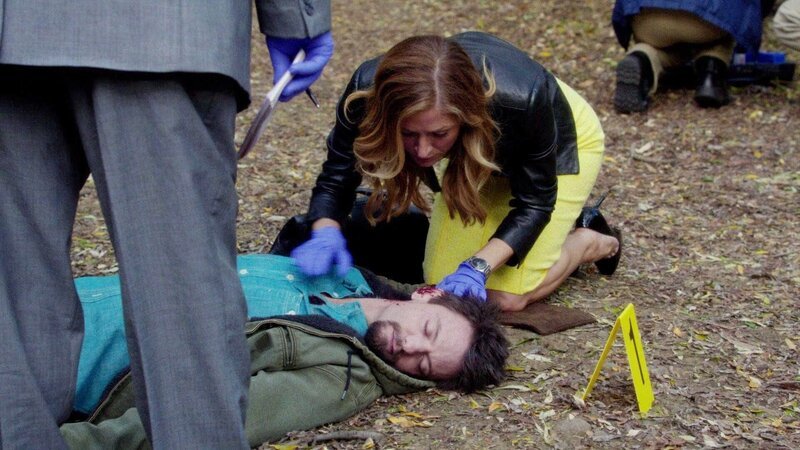 Maura Isles (Sasha Alexander) schaut sich die Leiche eines jungen Mannes (Darsteller unbekannt) genauer an. Das Opfer wurde erschossen und verstarb noch in dem Park. – Bild: RTL