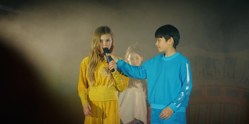 Celina (Lia Kahtin) und Noah (Hauke Tài Hoàng) moderieren gemeinsam die Darbietung der Jungs- und Mädels-Crew auf dem Talentwettbewerb. – Bild: ZDF/​StudioZentral