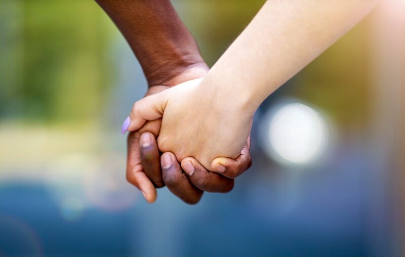 Interracial couple holding hands outdoors – Bild: Shutterstock /​ Shutterstock /​ Copyright (c) 2020 pikselstock/​Shutterstock. No use without permission.