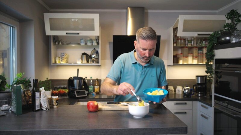 Achtet nun genau auf die Menge an Ballaststoffen: Christian J. macht sich zum Frühstück zum Beispiel körnigen Frischkäse mit Leinsamen, Haselnüssen, Ananas und Leinöl. – Bild: NDR/​Oliver Zydek