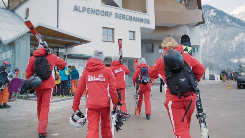Skilehrerinnen und Skilehrer morgens am Weg zur Gondelbahn. – Bild: ORF 1