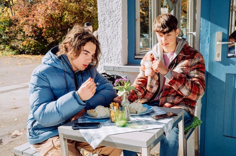Till (Marinus Hohmann, links) und Hacki (Timo Baran, KLD, rechts) versuchen, wie Spitzensportler, 10.000 Kalorien an einem Tag essen. – Bild: BR/​Nadya Jakobs/​Nadya Jakobs